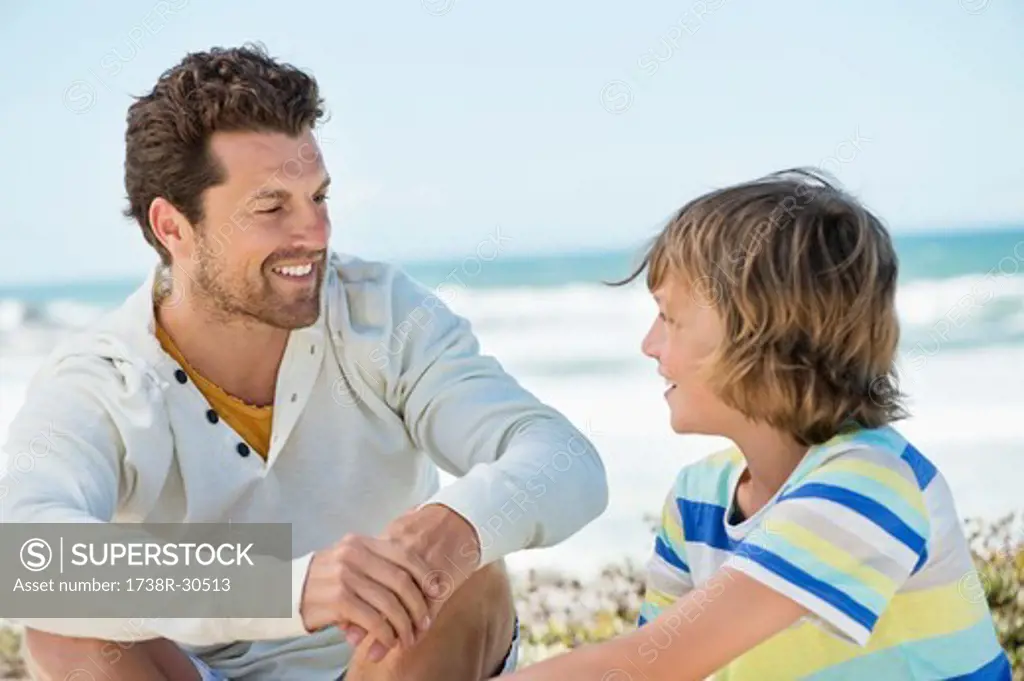 Man sitting with his son on the beach