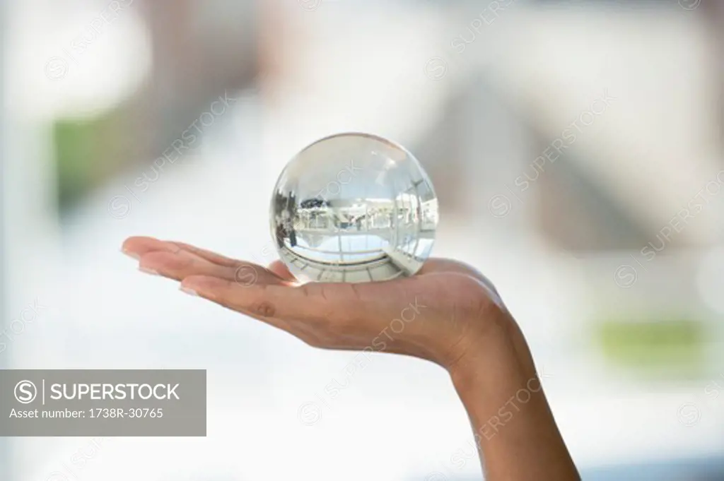 Close-up of a person's hand holding a crystal ball