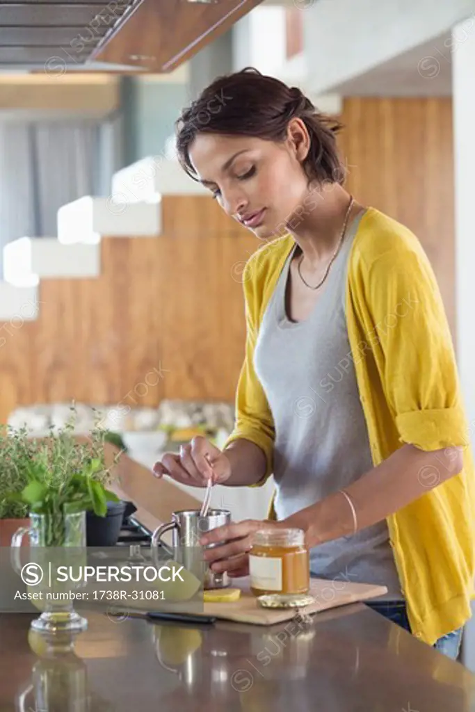 Woman preparing herbal tea in the kitchen