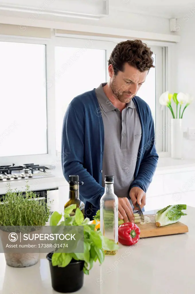 Man chopping vegetables in a kitchen