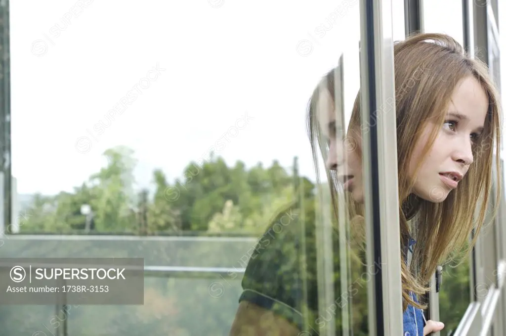 Thinking teenage girl at window