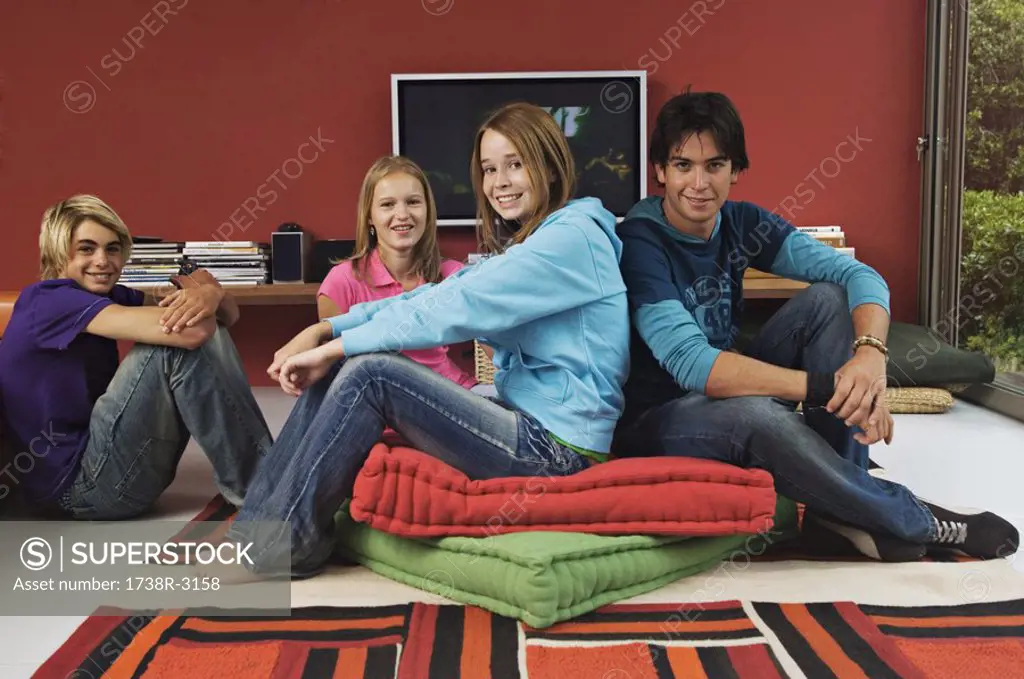 2 teenage girls and 2 teenage boys sitting in living-room