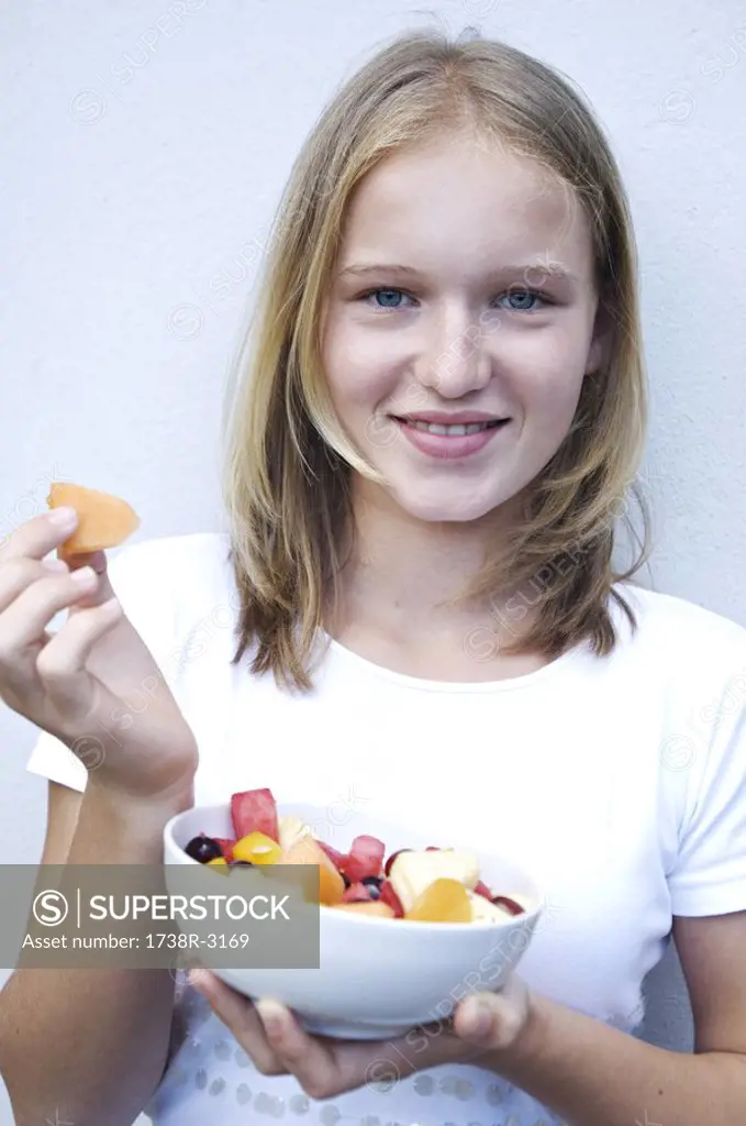 Portrait of a teenage girl eating fruit salad