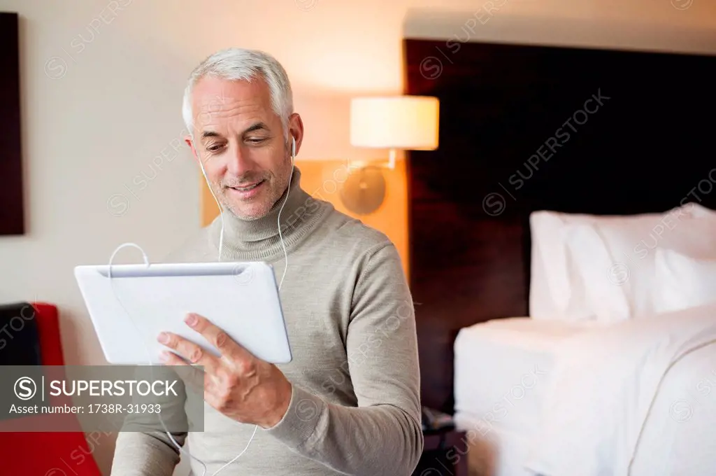 Man watching a movie on digital tablet in a hotel room