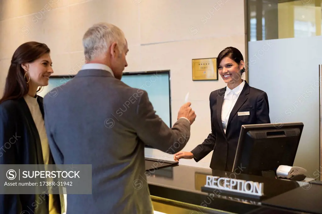 Business couple getting key card at the hotel reception counter