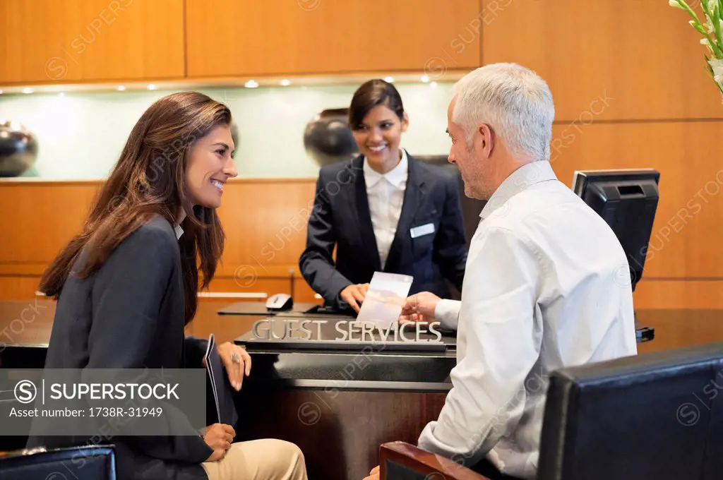 Business couple talking at a hotel reception counter