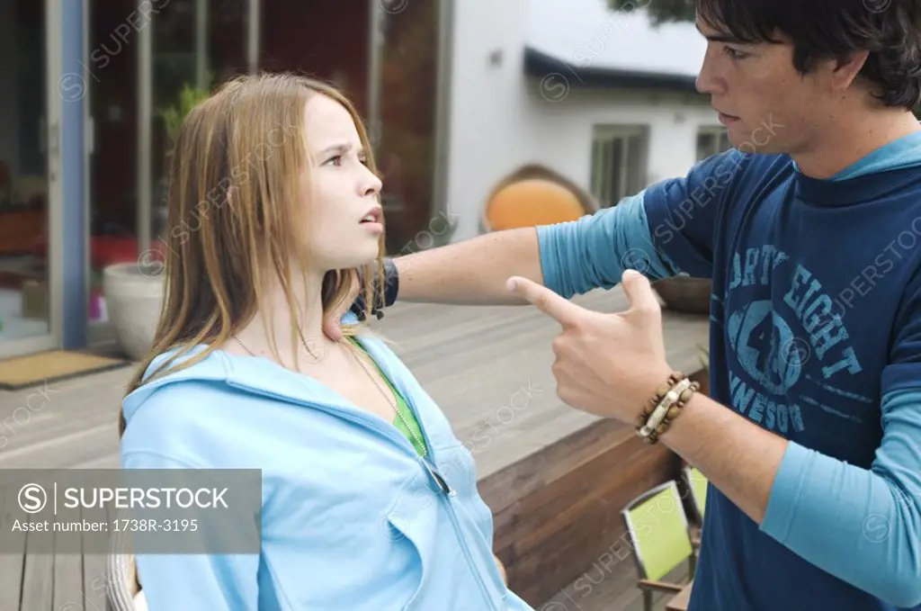 Teenage boy scolding teenage girl