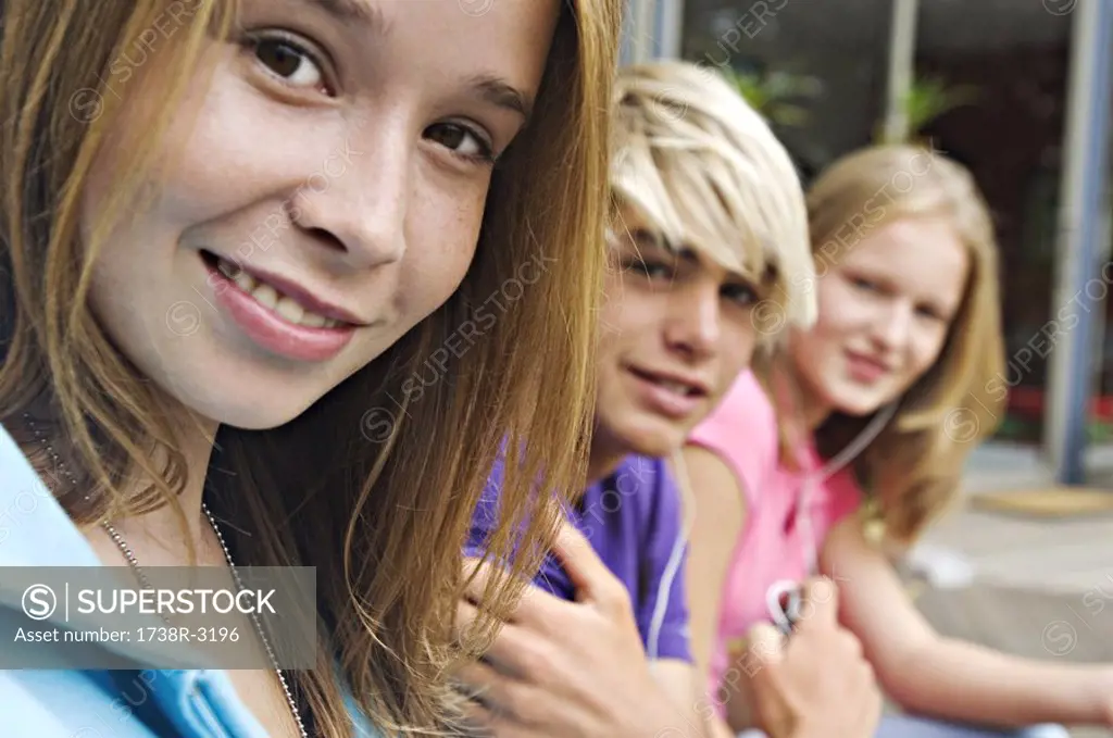 2 teenage girls and teenage boy smiling for camera