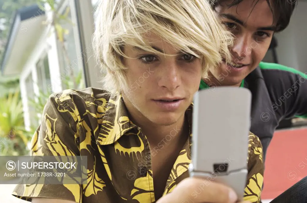 2 teenage boys using mobile phone