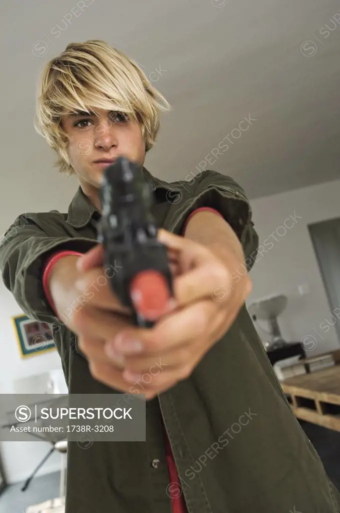 Teenage boy aiming handgun
