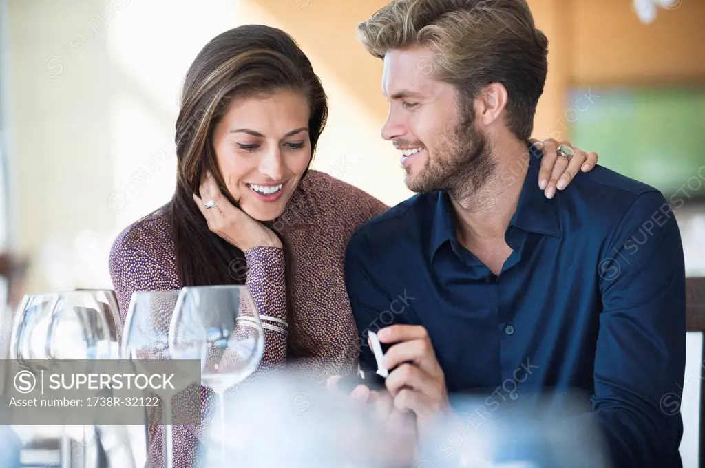 Man with engagement ring proposing his girlfriend in a restaurant
