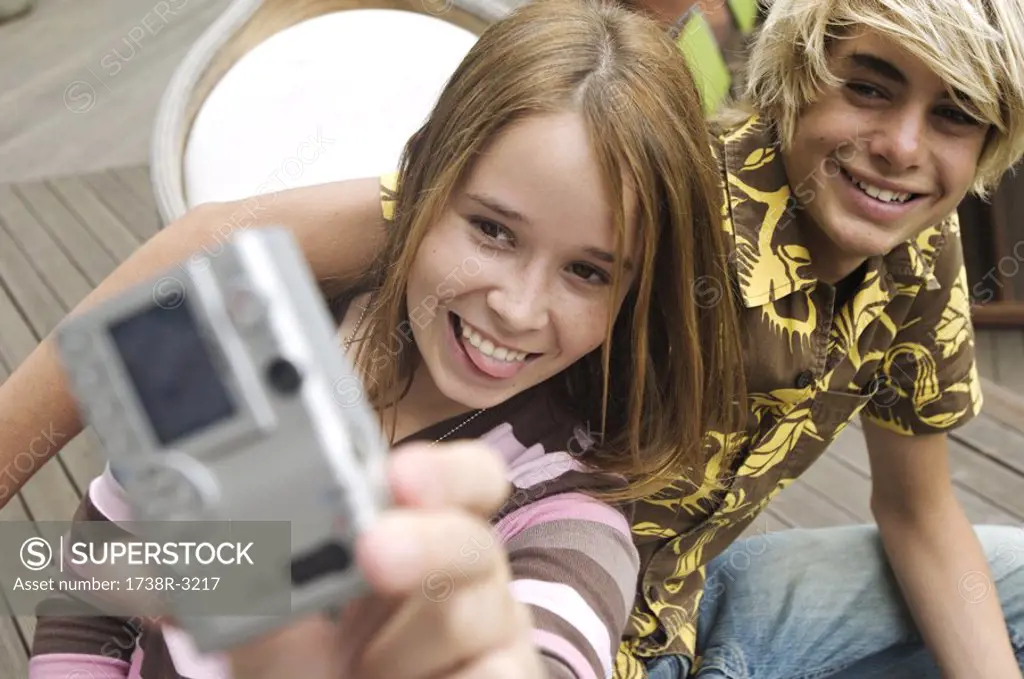 Teenage girl and boy photographing themselves