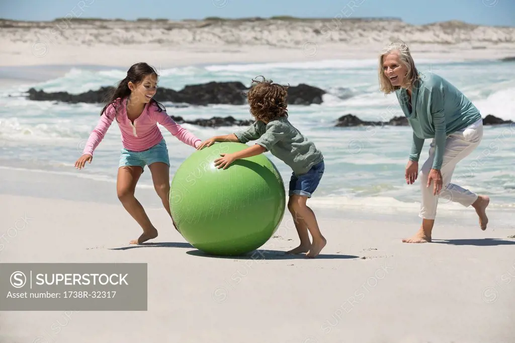 Woman playing with her grandchildren on the beach
