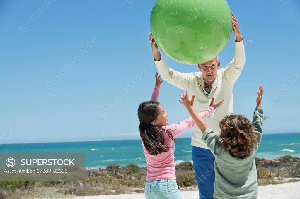Man playing with his grandchildren on the beach