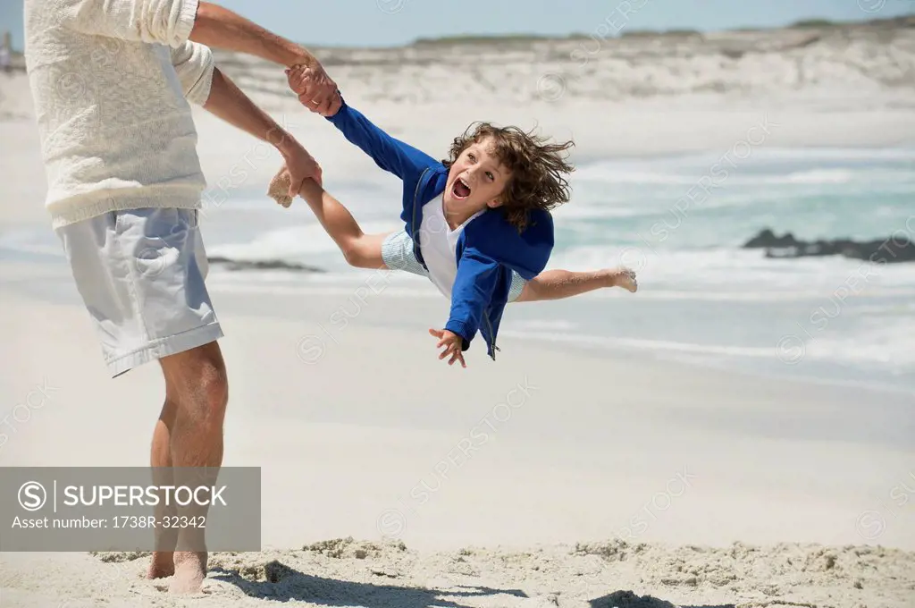 Man playing with his grandson on the beach