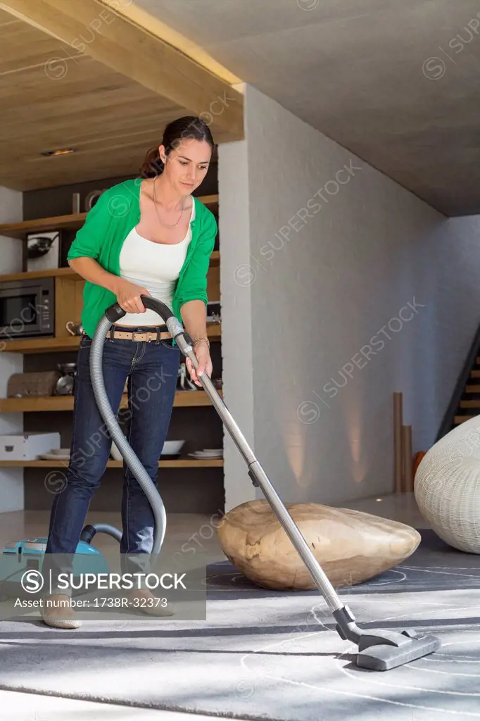 Woman cleaning house with a vacuum cleaner