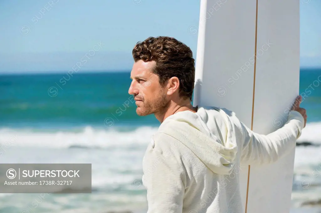 Man holding a surfboard on the beach
