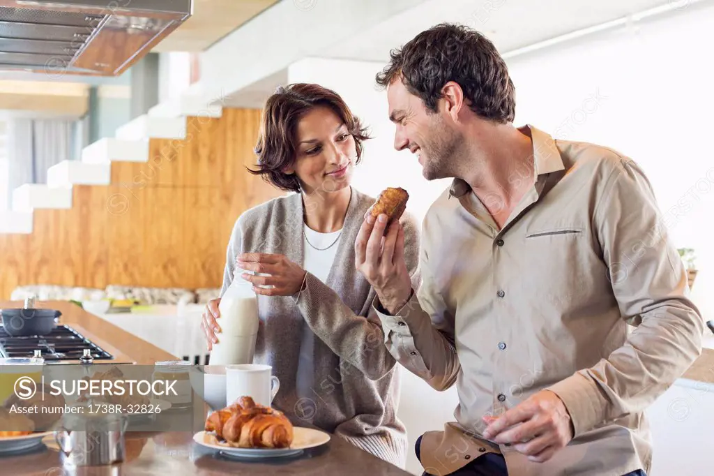 Couple having breakfast at a kitchen counter