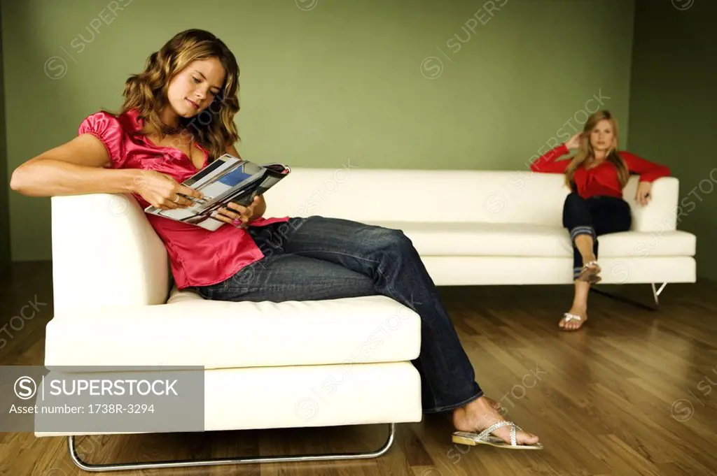 2 women reading on sofa