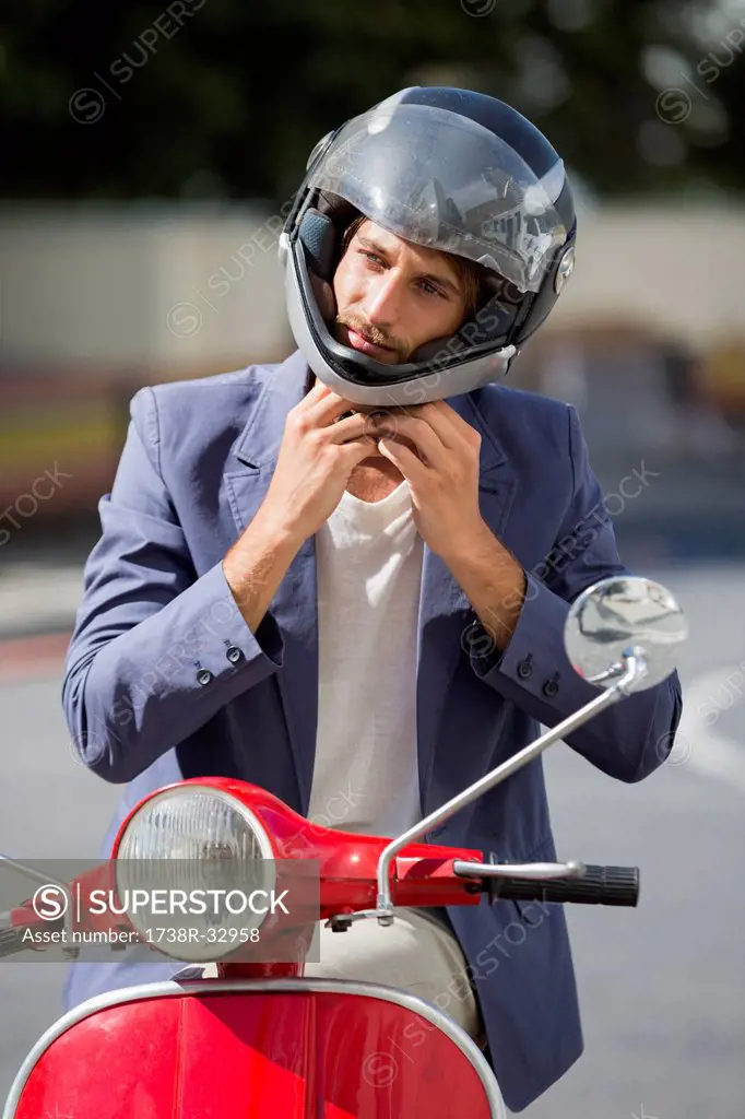 Man sitting on a scooter and wearing a helmet