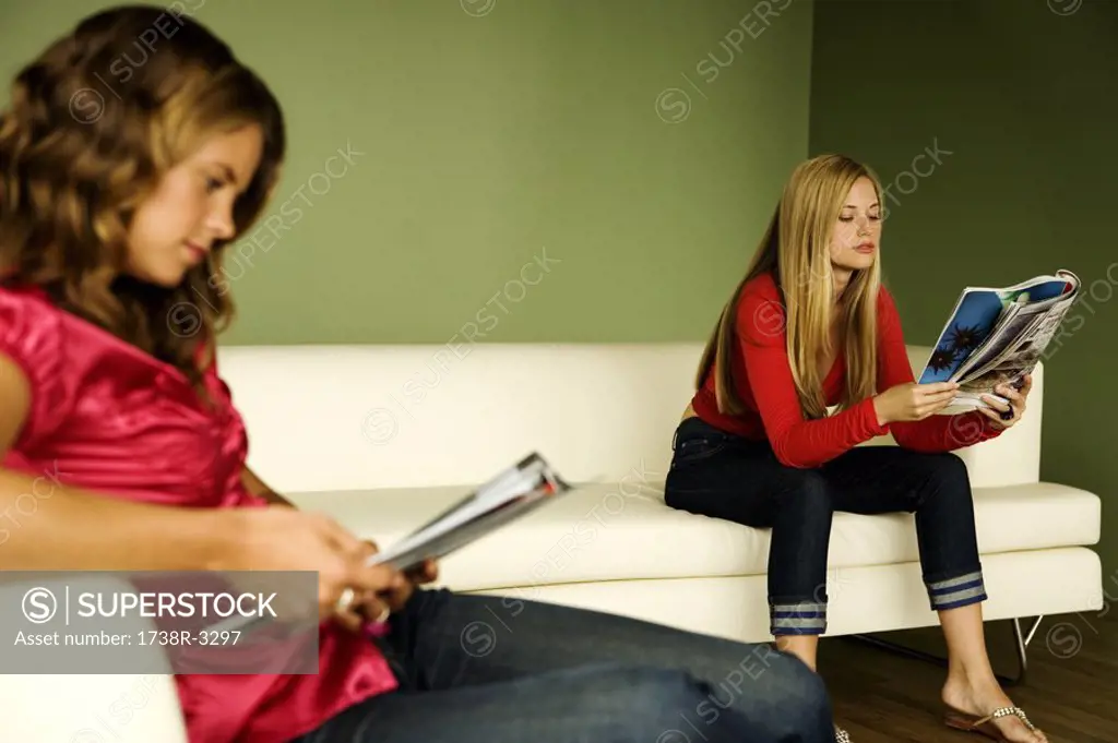 2 women reading on sofa