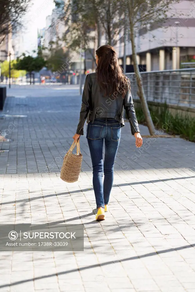 Rear view of a woman walking with a handbag