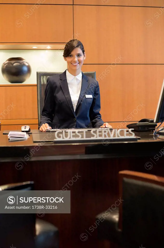Portrait of a receptionist smiling at the hotel reception counter