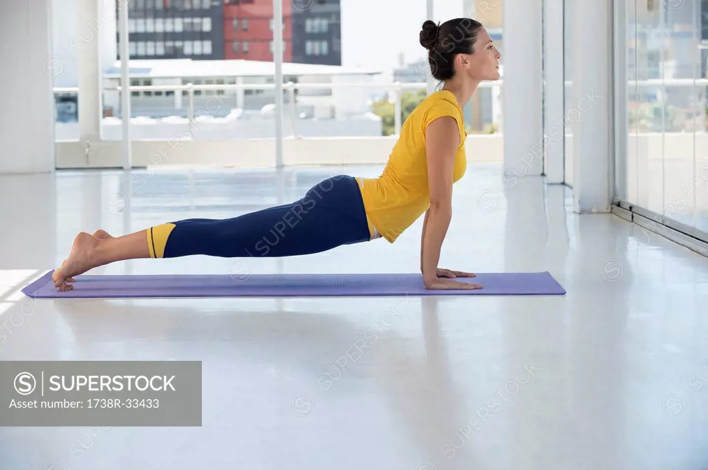 Woman exercising on exercise mat in a gym