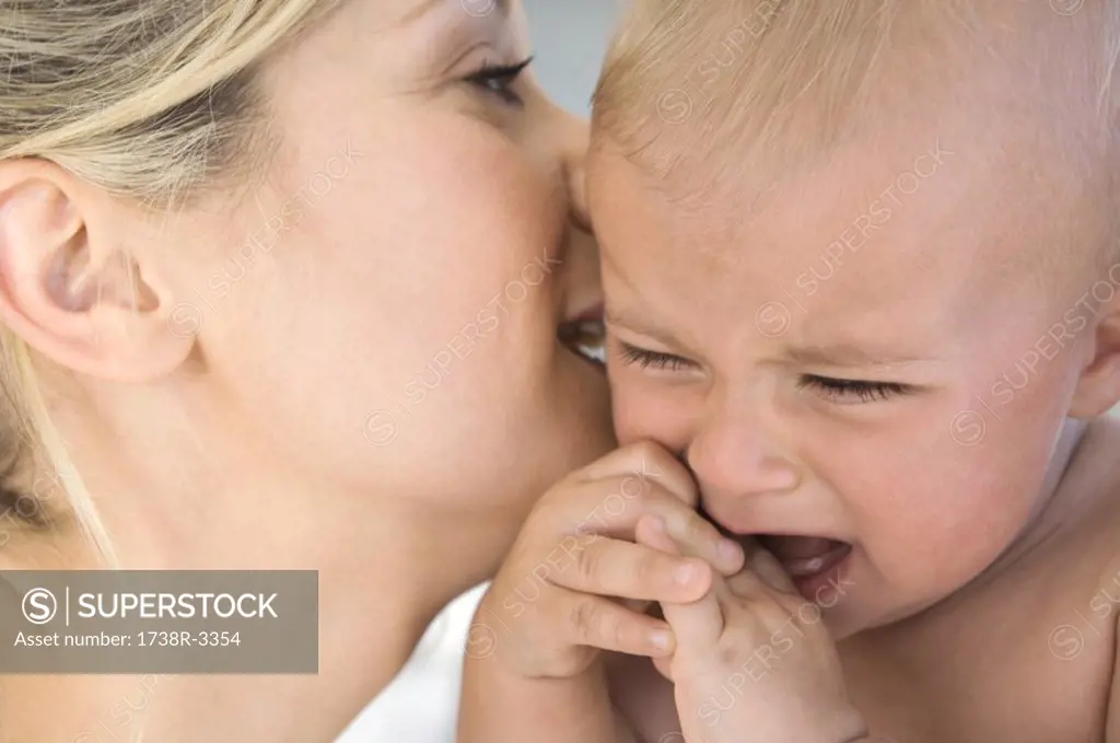 Portrait of a mother speaking to her baby, crying, indoors
