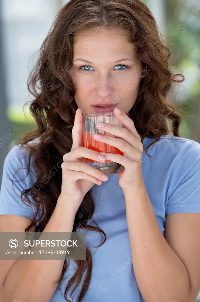 Portrait of a woman holding a glass of orange juice