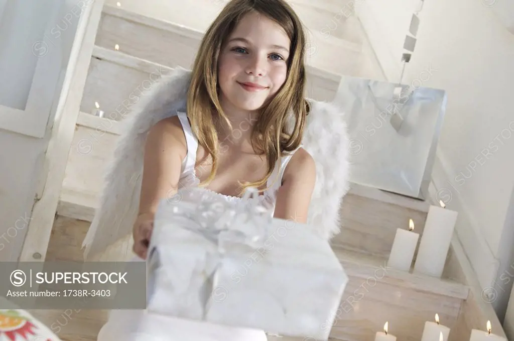 Little girl holding a Christmas present, indoors
