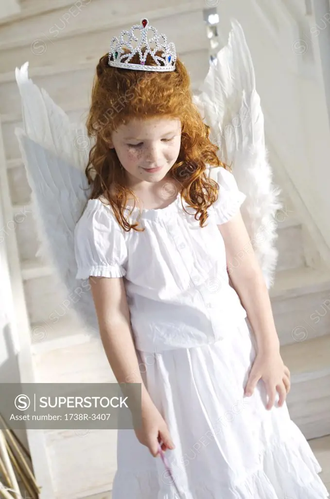 Little girl in an angel costume, indoors