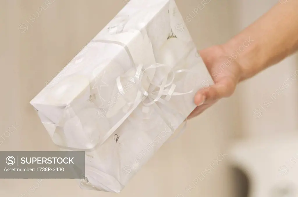 Man hand holding a present, close-up, indoors