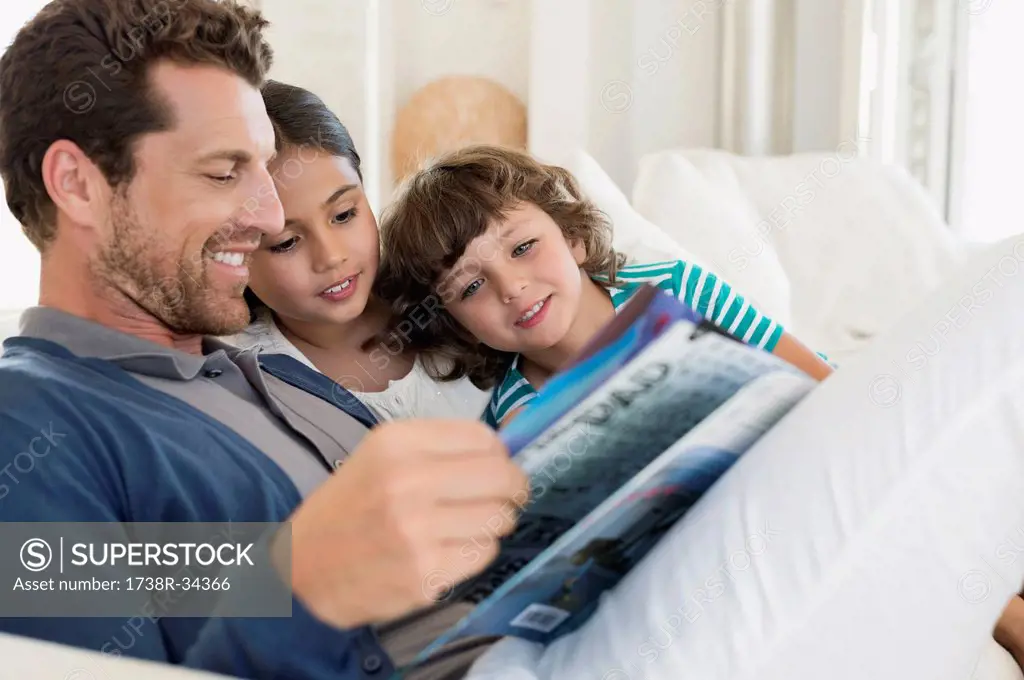 Man reading a magazine with his children