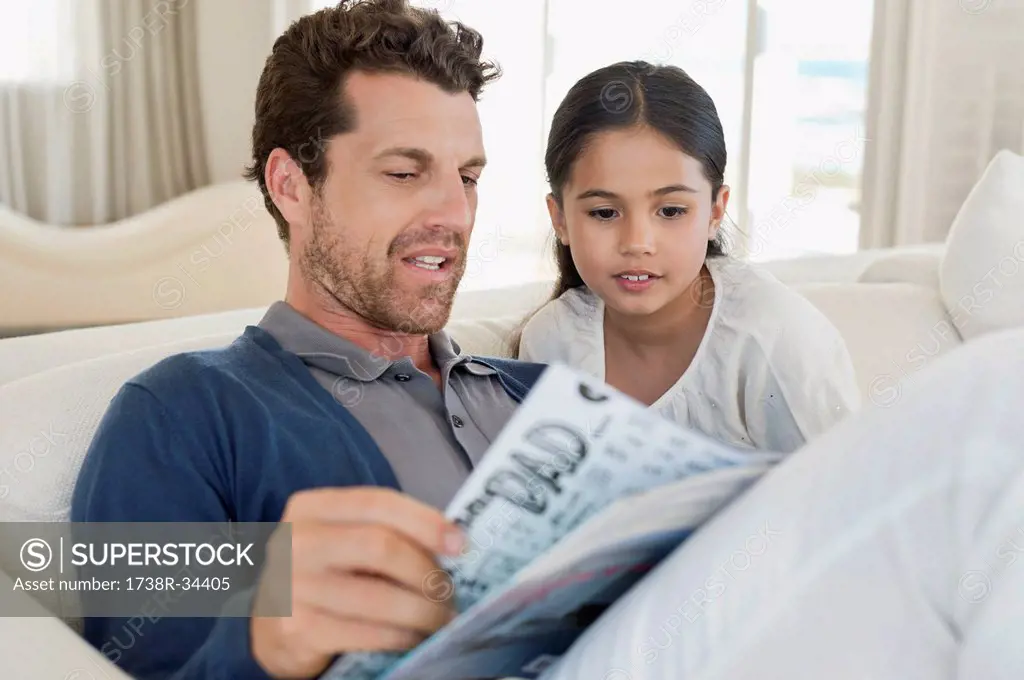 Man and his daughter reading a magazine