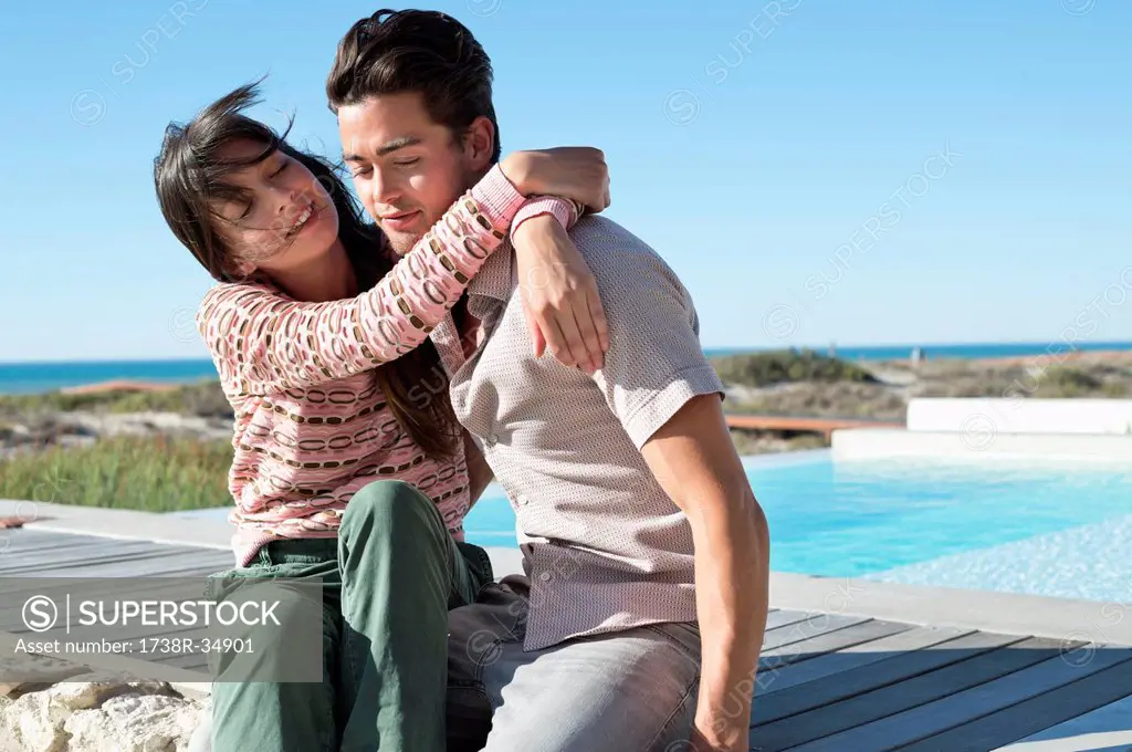 Romantic couple sitting on a boardwalk on the beach