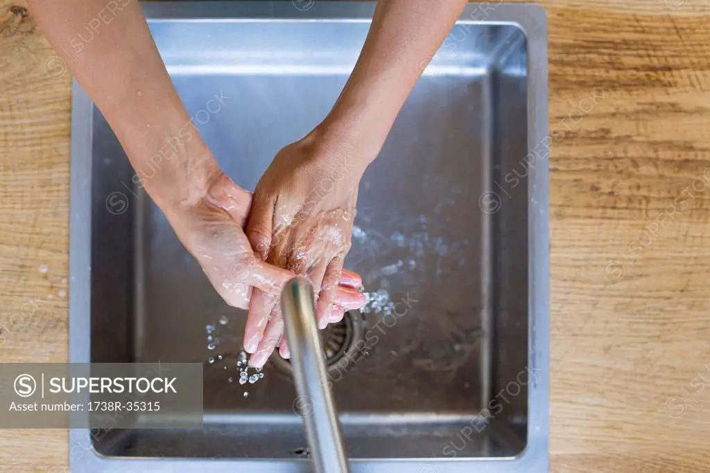 Woman washing her hands in the kitchen