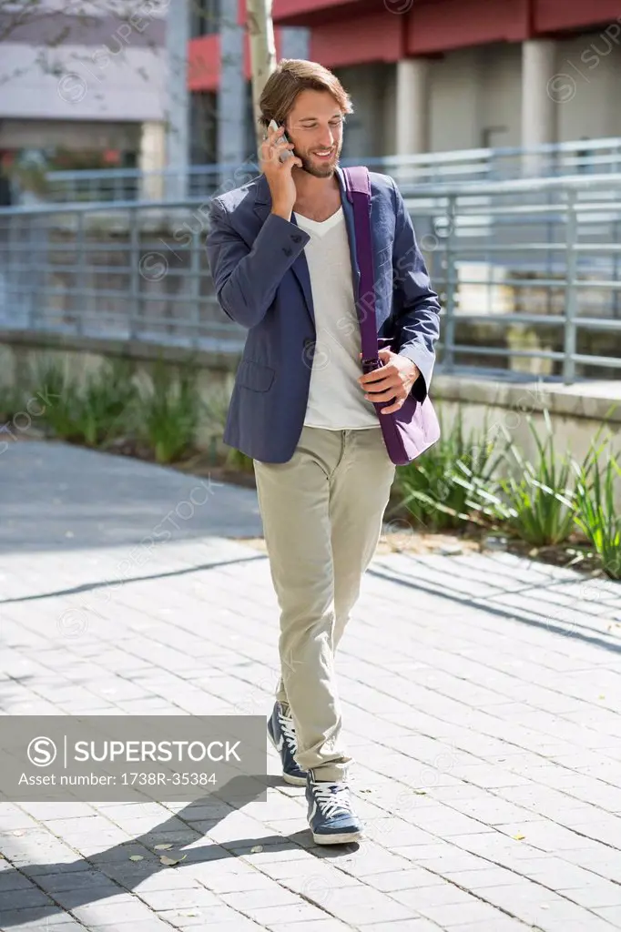 Man walking on a street and talking on a mobile phone