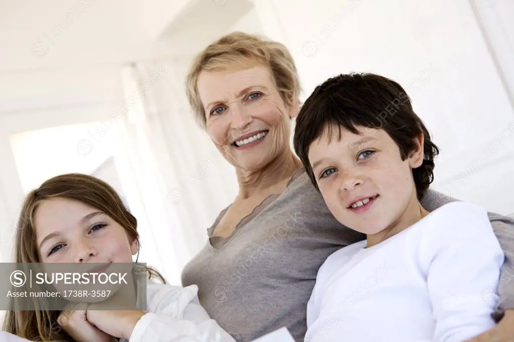 Senior woman and three children looking at the camera, indoors