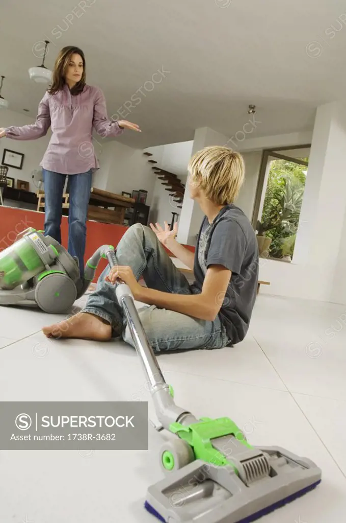 Mother and son in living room, vacuum cleaner, indoors