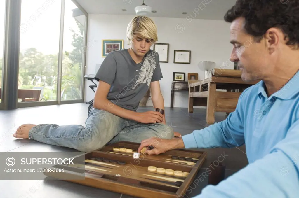 Father and son playing backgammon, indoors