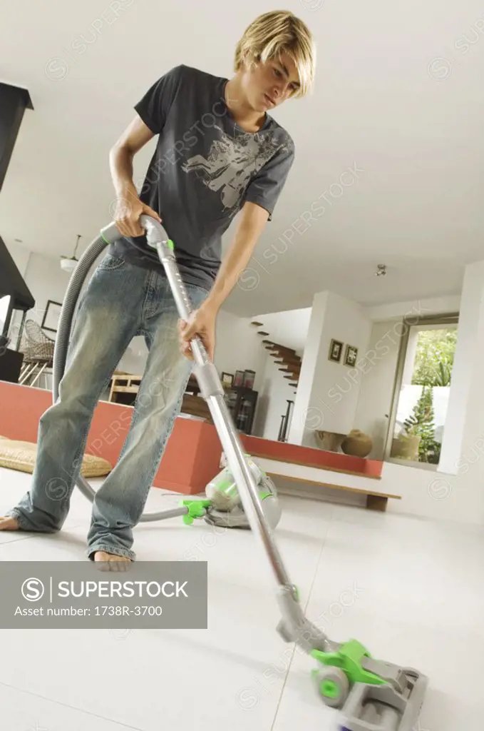 Teenager vacuuming, indoors