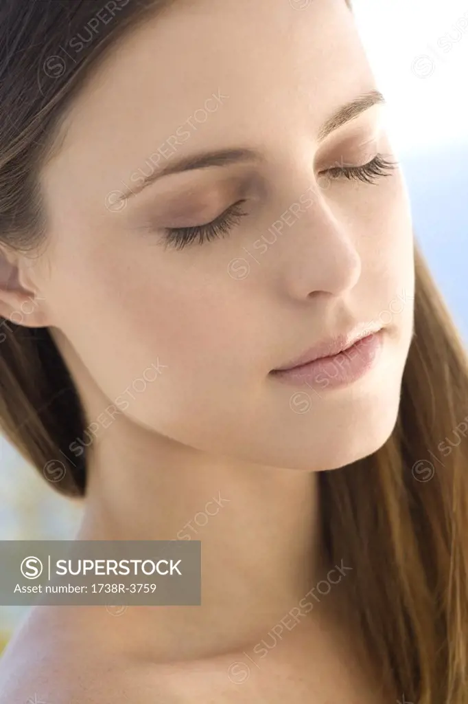 Portrait of a young woman, shut eyes, indoors