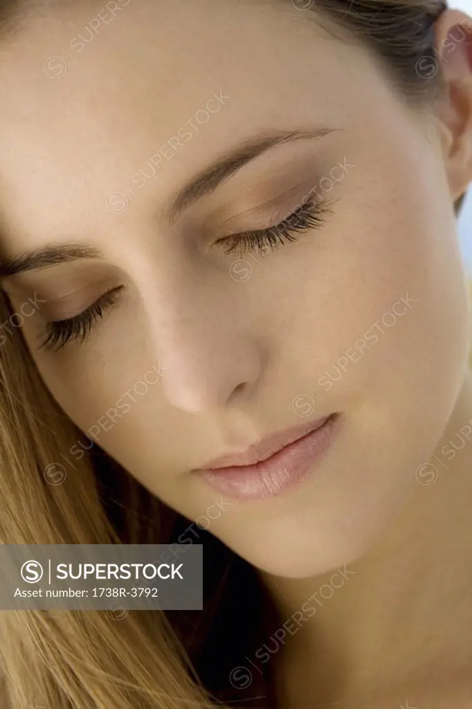 Portrait of a young woman, shut eyes, indoors