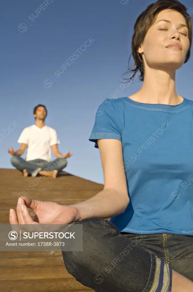 Couple in yoga attitude, outdoors
