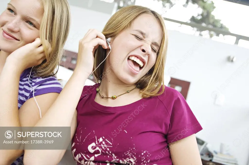 2 teen girls sharing MP3 player