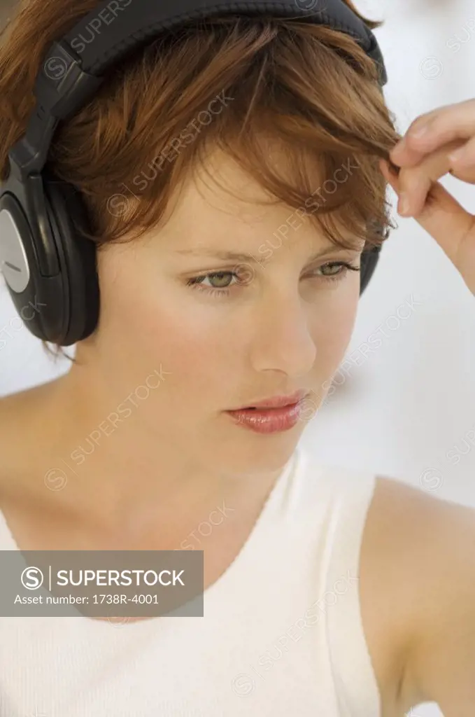 Portrait of a young woman, listening to music with headphones
