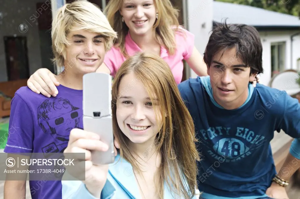4 teenagers using camera phone