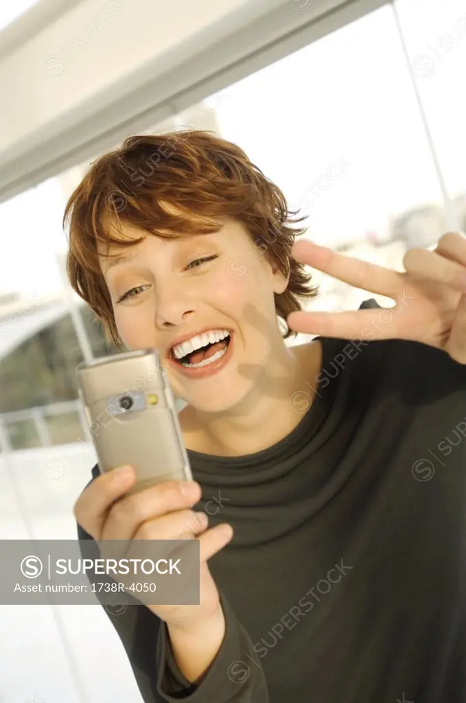 Portrait of a smiling woman using camera phone