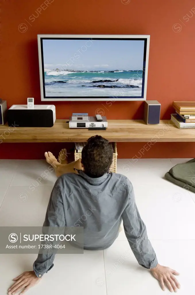 Man watching TV sitting on floor